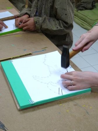 Création d'un tableau de fil de laine en atelier avec les enfants : clous et marteaux